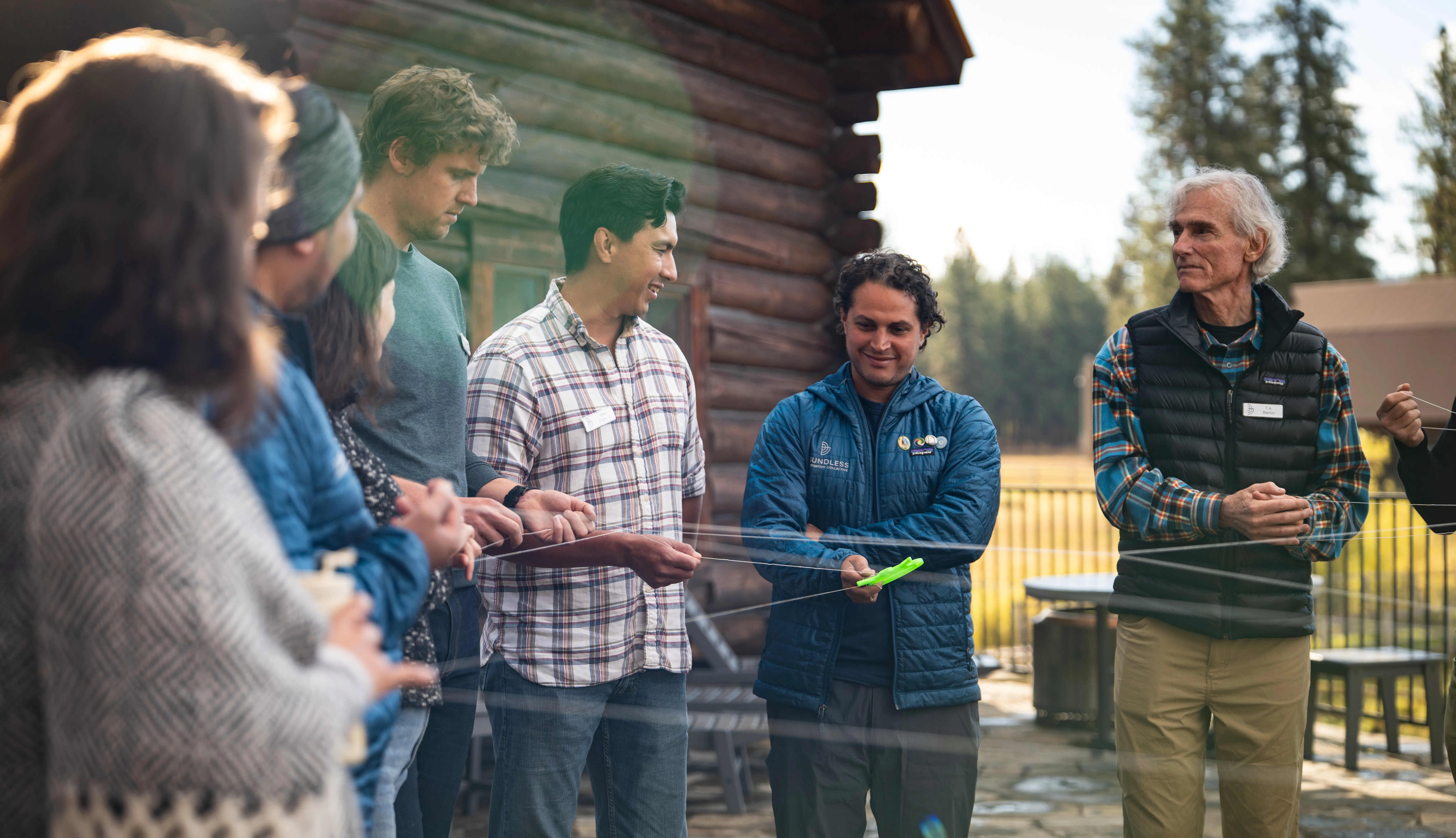 A group of people laughing and smiling around a table full of books and papers